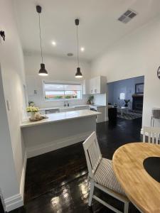 een keuken en eetkamer met een tafel en een aanrecht bij Daisy Cottage, 4 bedrooms, close to CBD in Golden Square