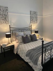 een slaapkamer met een bed met 2 lampen en kussens bij Daisy Cottage, 4 bedrooms, close to CBD in Golden Square