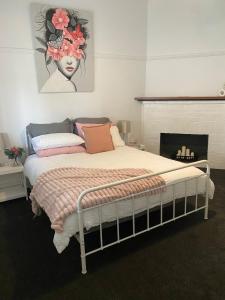 een slaapkamer met een bed met een bloemschilderij aan de muur bij Daisy Cottage, 4 bedrooms, close to CBD in Golden Square