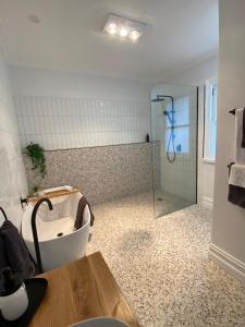 een badkamer met een bad en een douche bij Daisy Cottage, 4 bedrooms, close to CBD in Golden Square +11 foto's