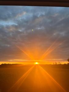 einen Sonnenuntergang mit der Sonne am Himmel in der Unterkunft Serene Loft Retreat in Münster