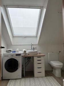 ein Badezimmer mit Waschbecken und Waschmaschine in der Unterkunft Serene Loft Retreat in Münster