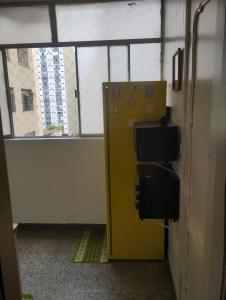 a yellow box in a room with a window at Vagas Carnaval AP no Centro de BH in Belo Horizonte