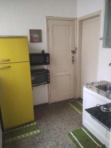 a kitchen with a yellow refrigerator and a door at Vagas Carnaval AP no Centro de BH in Belo Horizonte +25 photos