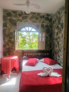 two beds in a room with two swans on them at Pousada Iansã in Vera Cruz de Itaparica