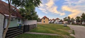 a house with a fence and a yard with houses at Apartma Zala in Brežice
