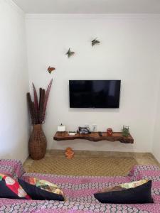 a living room with a flat screen tv on a wall at Casa do Lago Sairé in Sairé