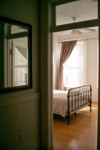 a bedroom with a bed with a window and a mirror at Object Hotel 2BR Room 2B in Bisbee