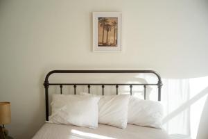 a bed with a black frame and white pillows at Object Hotel 2BR Room 2B in Bisbee