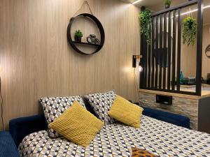 une chambre avec un lit avec deux oreillers et un miroir dans l'établissement le petit gîte de mag, à Plouha