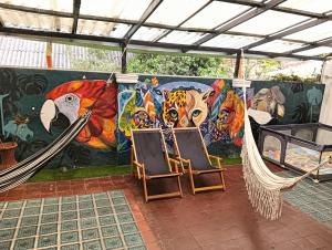 a mural with two chairs and a hammock in front at Casa Samor La Candelaria in Bogotá