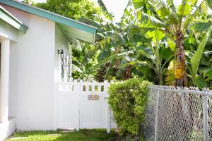 a white fence in front of a white house at Tangerine Sunsets Skylark in Nassau