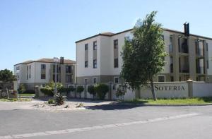 an empty parking lot in front of a building at Beautiful 2 bedroom apartment in strand in Somerset West