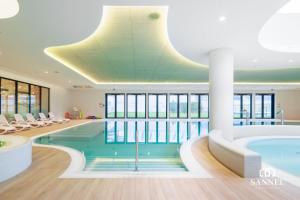una piscina in un hotel con un grande soffitto di Apartament Baltic Dune z dostępem do basenów,jacuzzi,strefy saun - Pinea Apartments Pobierowo-SANNEL Apartments for rent a Pobierowo