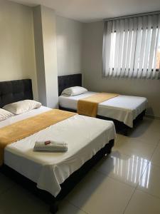 Postel nebo postele na pokoji v ubytování Hotel Escorial Ibagué