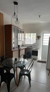 a kitchen and dining room with a glass table and chairs at casa ipê sobrado Pindamonhangaba, Moreira César in Pindamonhangaba +17 photos