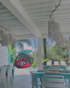 a patio with tables and chairs and a swing at Siloe Cove Hospedaje Campestre in San Andrés
