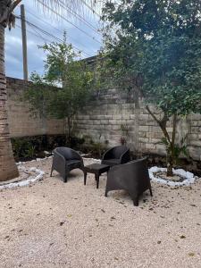 Tre sedie nere e un tavolo di fronte a un muro di Casa Colonos a Valladolid