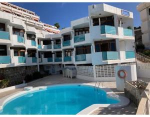 a building with a swimming pool in front of a building at New Puerto Rico Terrace Swiming Pool in Mogán