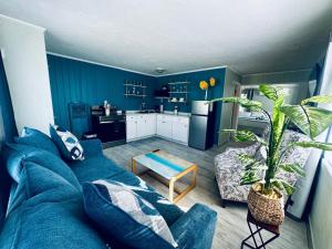 a blue living room with a blue couch and a kitchen at Playa Esmeralda INN Suite 2 in Bradenton Beach
