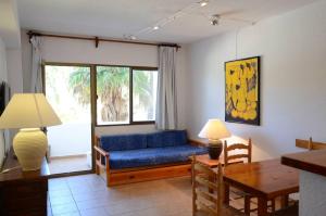 a living room with a blue couch and a table at Costamar 13 in Es Pujols +16 photos