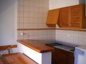 a kitchen with wooden cabinets and a counter top at Costamar 13 in Es Pujols