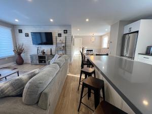 a living room and kitchen with a couch and a counter at The Luxe Lodge in Algonquin Highlands