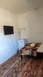 a room with a bed and a tv on the wall at Pousada Iansã in Vera Cruz de Itaparica