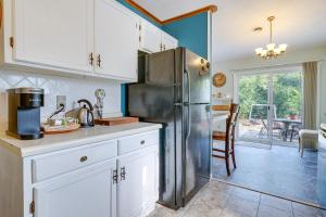 a kitchen with white cabinets and a stainless steel refrigerator at Pet-Friendly Wilmington Home with Fenced Yard! in Wilmington