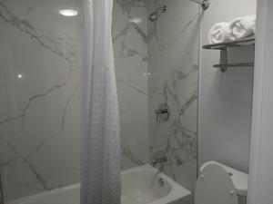a bathroom with a shower curtain and a toilet at Baymont by Wyndham Rock Hill in Rock Hill +13 photos