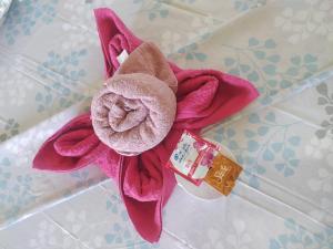a pink flower on a counter with a bar of soap at Kakuna Lodge in Minca