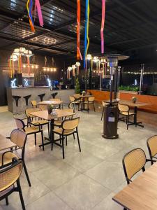 ein Restaurant mit Tischen, Stühlen und Lichtern in der Unterkunft UKUKU Hostel in Quito