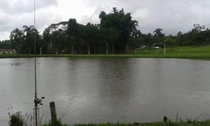 a large body of water with a fishing rod in it at Pesqueiro ABUX in Mogi das Cruzes