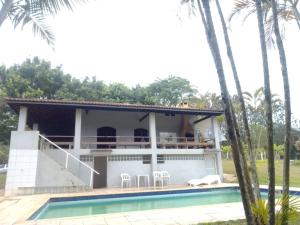 a villa with a swimming pool and a house at Pesqueiro ABUX in Mogi das Cruzes