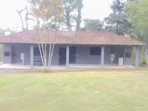 a small white building with a red roof at Pesqueiro ABUX in Mogi das Cruzes