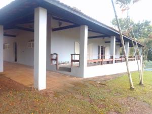 a white building with a blue roof at Pesqueiro ABUX in Mogi das Cruzes