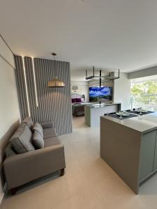 un salon avec un canapé et une cuisine dans l'établissement Studio de Alto Padrão no Jardim Aquarius, à São José dos Campos