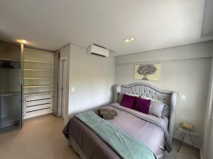- une chambre avec un lit et des oreillers violets dans l'établissement Studio de Alto Padrão no Jardim Aquarius, à São José dos Campos