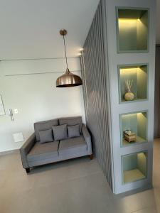 sala de estar con sofá y pared en Studio de Alto Padrão no Jardim Aquarius, en São José dos Campos