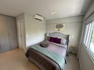 - une chambre avec un grand lit et des oreillers violets dans l'établissement Studio de Alto Padrão no Jardim Aquarius, à São José dos Campos 26 autres photos