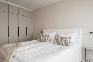 a white bedroom with a large white bed with pillows at Borg Itsenäisyydenkatu, Centre Spacious 2-Room Apt, King Bed, Free Parking & Wifi in Pori