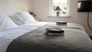 two towels sitting on a bed in a bedroom at Bed and Breakfast De Reggestee in Hellendoorn