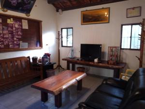 a living room with a wooden table and a desk at Hong Wa Cuo南投埔里紅瓦厝山居民宿森林系住宿生態手作體驗 in Puli
