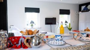 una tavola ricoperta di piatti e ciotole di cibo di Bed and Breakfast De Reggestee a Hellendoorn Altre 6 foto