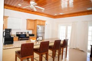 a kitchen with a large table with chairs and a ceiling at Tangerine Sunsets Satsuma One in Nassau