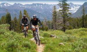 two people riding bikes on a trail in the mountains at Plush Mammoth Condo W Balcony Views in Mammoth Lakes