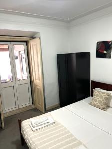 a bedroom with a bed and a sliding door at São Lázaro Bhuiyan Family Host in Lisbon +15 photos