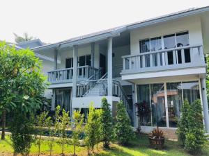 a large white house with a balcony at Casa Sakhu Beach Villa Phuket in Nai Yang Beach