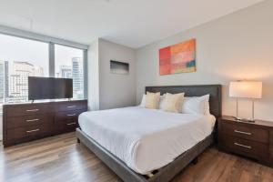 Un dormitorio con una cama y un televisor de pantalla plana. en Private Apt Seaport with Gym, en Boston