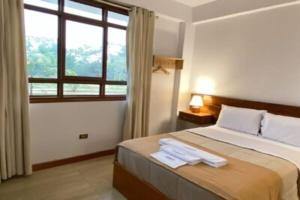 Tantiri River Resort في بويرتو مالدونادو: غرفة نوم بها سرير عليه منشفتان +11 صورة